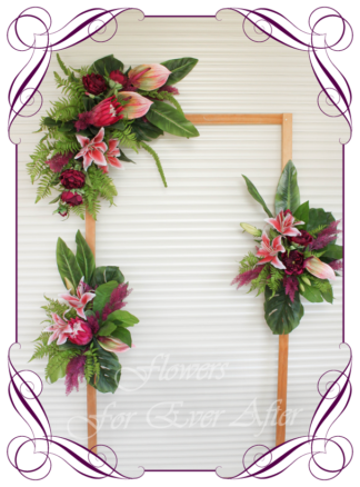 A Gorgeous Silk Artificial Australian tropical arbor arch wedding table decoration featuring faux flower lilies, anthurium, fuchsia pink protea, plum peonies, monsteria, wedding decoration set. Made in Melbourne by Australia's Best Artificial Bridal Florist. Worldwide Shipping available