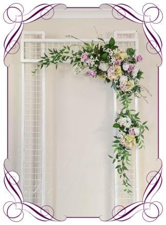 Silk artificial mauve lilac, green and white modern romantic wedding flowers wedding arbor arch background decoration. Hydrangea, white roses lilac roses on a garland, silk wedding florals, unusual romantic realistic fake wedding decoration design. Bridal table centrepiece flowers. Made in Melbourne Australia. Buy online..
