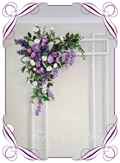 Silk artificial white and lilac purple romantic luxe wedding flowers wedding arbor arch background decoration. Lilacs, chrysanthemum, wisteria, roses silk wedding florals, unusual romantic realistic fake wedding decoration design. Bridal table centrepiece flowers. Made in Melbourne Australia. Buy online..